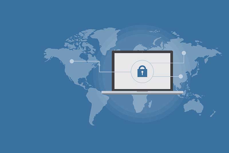 Protection des données globale : un cadenas sur un écran d'ordinateur superposé à une carte du monde, symbolisant la sécurité informatique internationale.