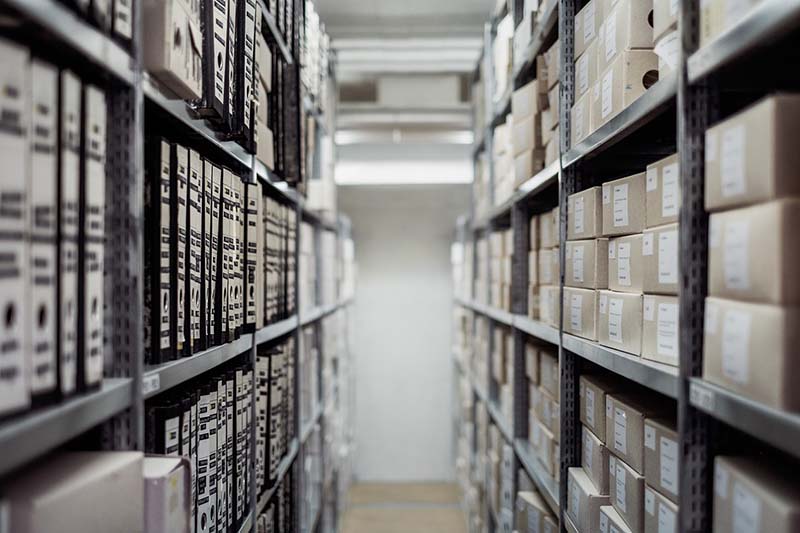 Des étagères remplies de dossiers et boîtes d'archives, évoquant un registre méticuleux de traitement des données personnelles.